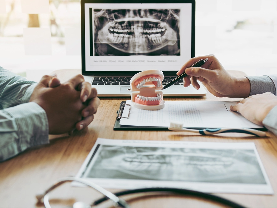 White label AI-optimized Google Business Profile for dentists — doctor explaining with teeth model representing enhanced local dental visibility
