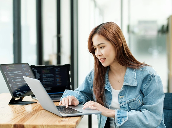 White label Beaver Builder developer-friendly workflow — developer working on laptop with code visible across multiple screens for custom website development