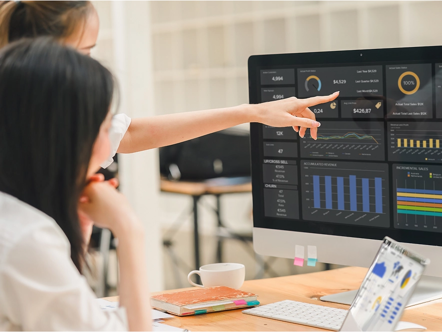 White label campaign optimization, bidding and performance scaling — team discussing analytics on desktop with performance graphs