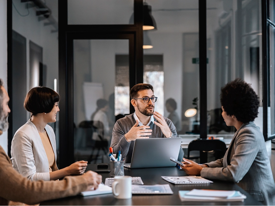 White label communication support — team collaborating around table with laptop, notes and tools ensuring clear communication and project updates