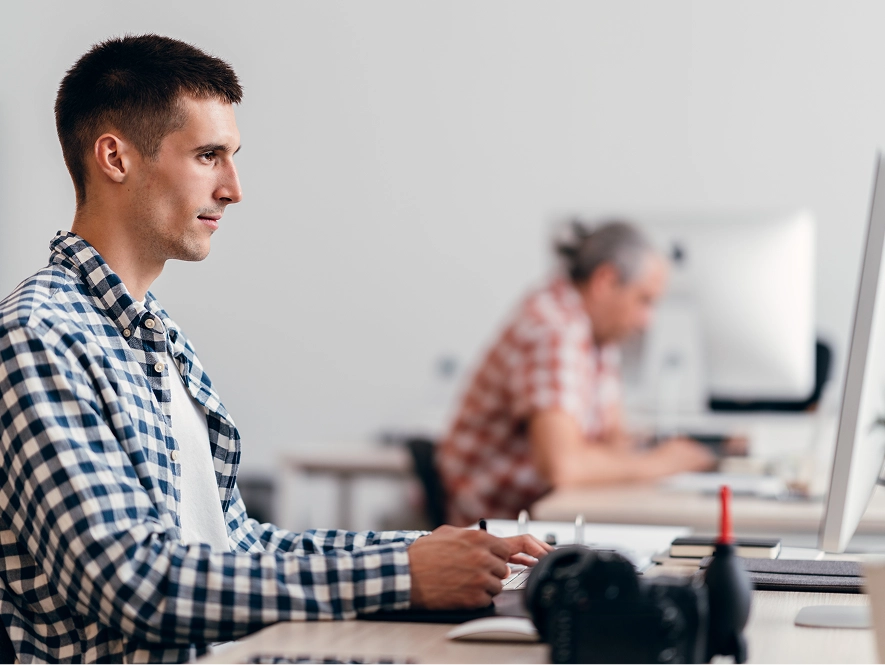 White label corporate and marketing video editing — professional focused on desktop with editing tools and notes in hand