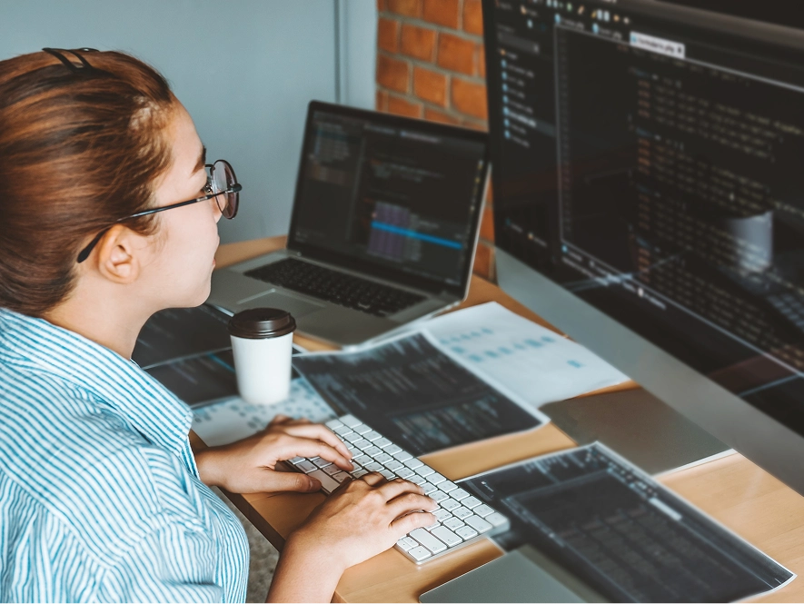 White label Duda support and maintenance — developer reviewing code and support tasks on desktop with notes and documents on workspace