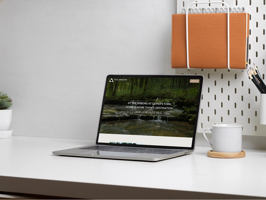 White label Duda web design and development — laptop on table displaying website builder with coffee cup and diary in workspace