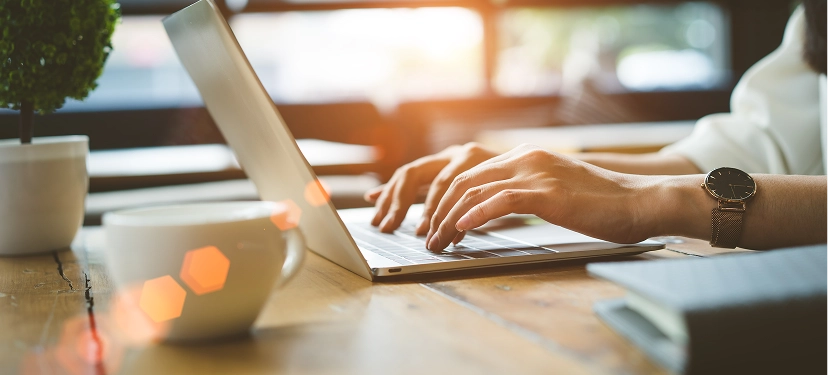 White label ecommerce copywriting services — professional working on laptop with notes and coffee on table creating high-converting product content
