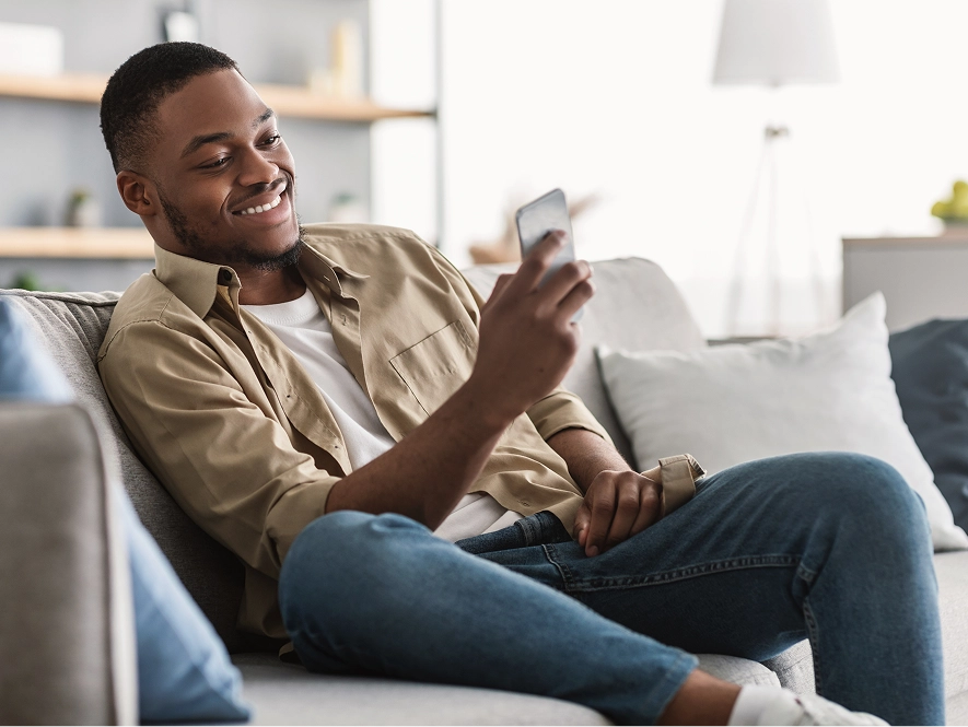 White label LinkedIn ad formats and campaign execution — user relaxing on sofa while managing campaigns on mobile