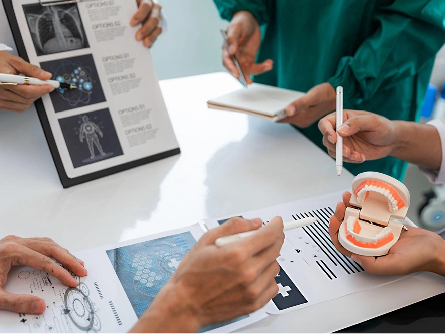 White label local SEO for dental practices — team discussing dental case with tablet displaying teeth diagram and treatment visuals for local marketing strategy