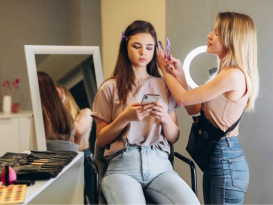 White label local SEO for salons and beauty businesses — stylist working on customer hair in salon environment to represent local service visibility