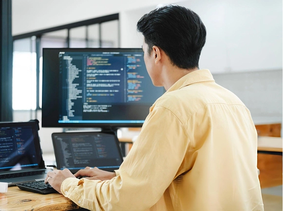 White label Oxygen Builder full developer control — developer coding across multiple screens with website code and custom functionality visible on devices