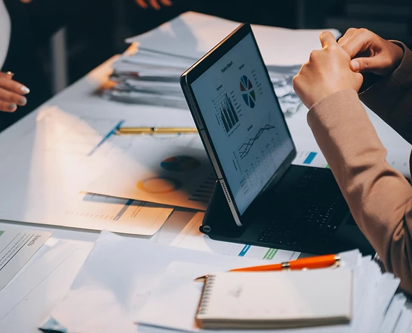 White label PPC proposals and sales support — professional reviewing laptop with graphs alongside paper and pen for planning and presentation
