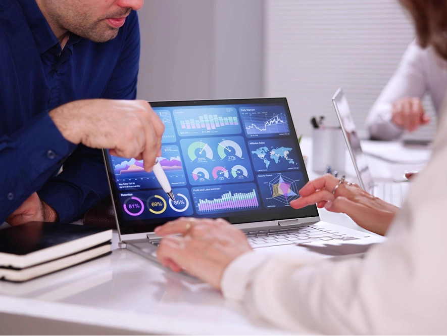 White label reporting and analytics — team reviewing and explaining performance on laptop with graphs and score metrics