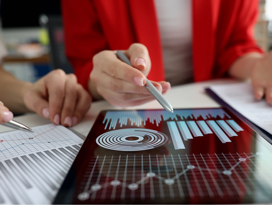 White label reporting and analytics — reviewing graphs on iPad with pen and analyzing printed performance reports