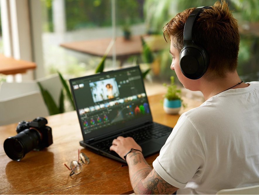 White label short-form and social media video editing — editor working on laptop with headphones and video editing interface on screen