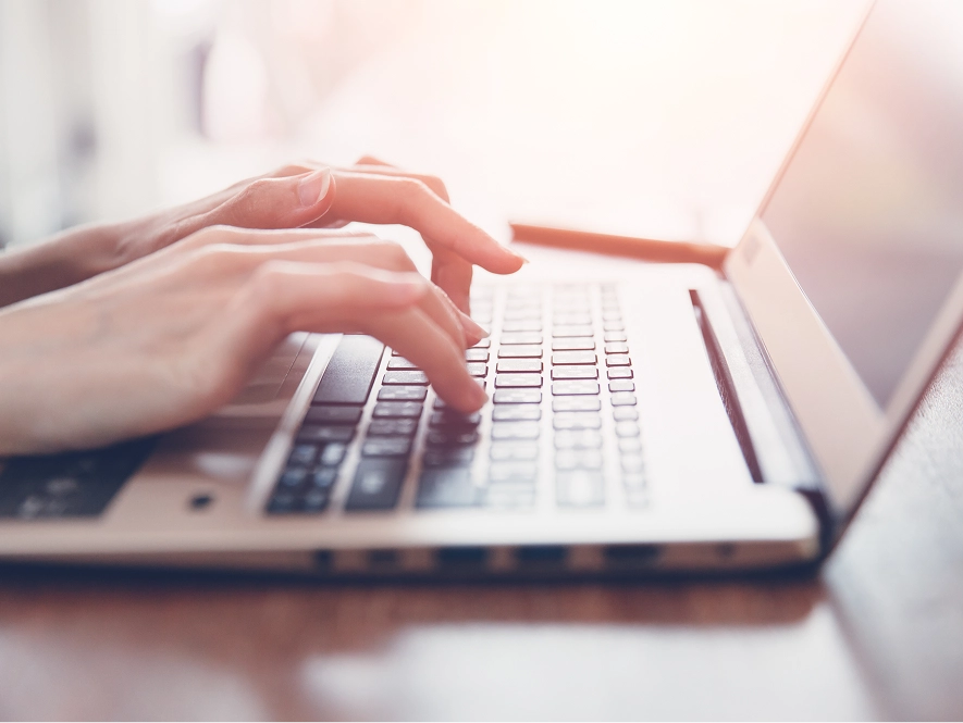 White label website content writing services — typing on laptop placed on table for content creation