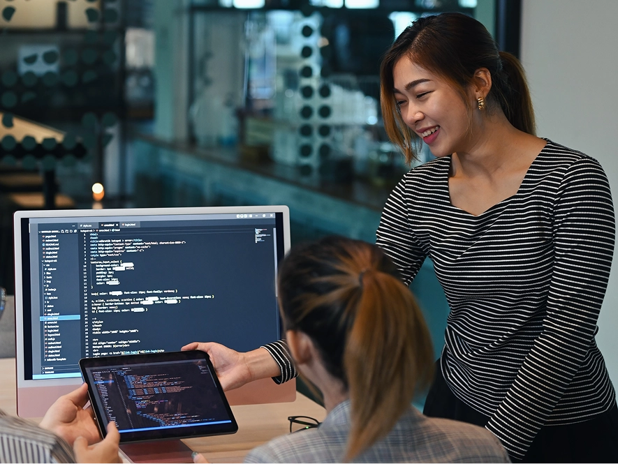 White label WooCommerce custom development and integrations — professional presenting code on tablet to colleague for advanced ecommerce functionality