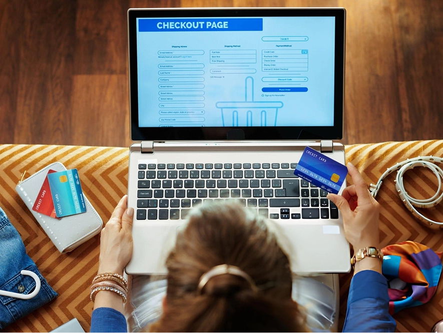 White label WooCommerce payment gateways and checkout experiences — user completing online purchase on laptop with card in hand and products on table for secure ecommerce transactions